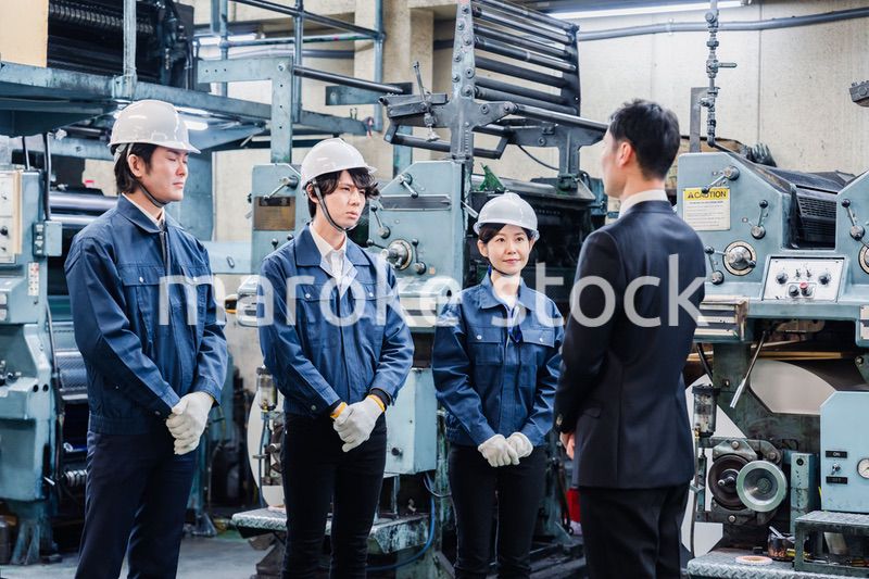 管理職の訓示を聴く工場スタッフ