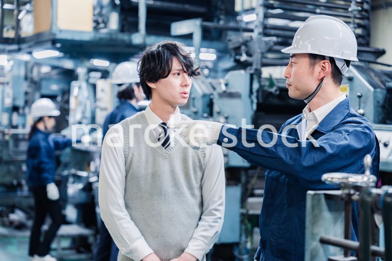 工場を見学する男子学生