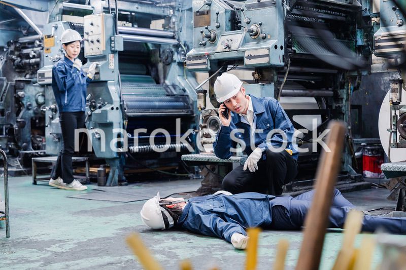 工場で救急通報をする従業員