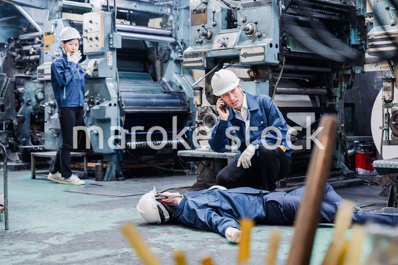 工場で救急通報をする従業員