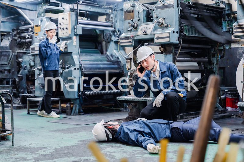 工場で救急通報をする従業員