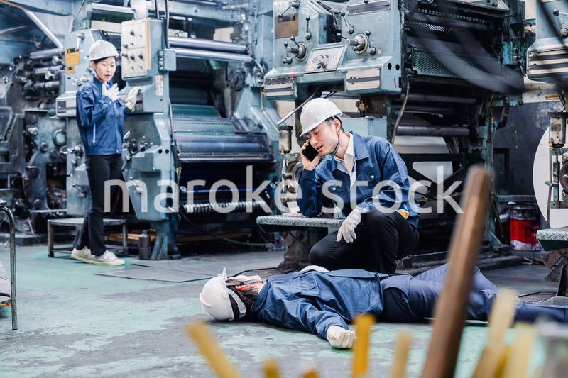 工場で救急通報をする従業員
