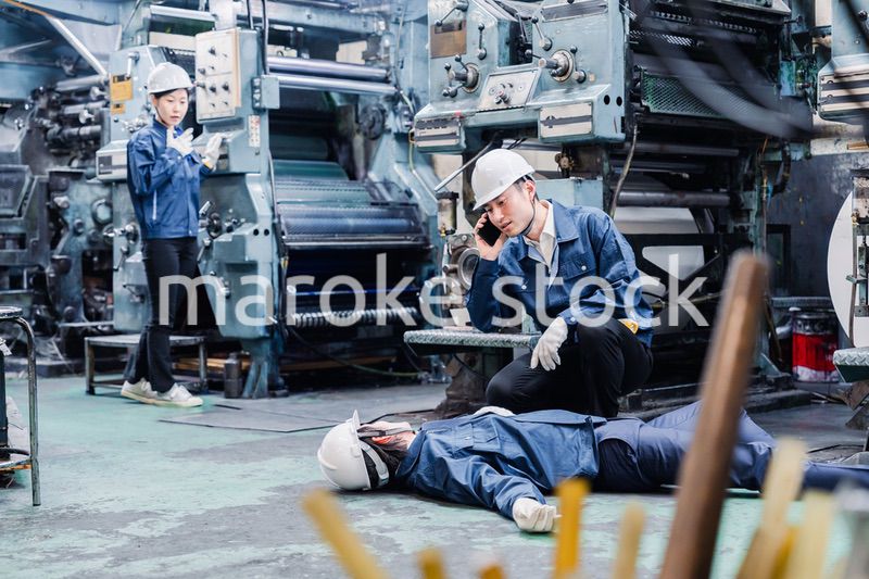 工場で救急通報をする従業員