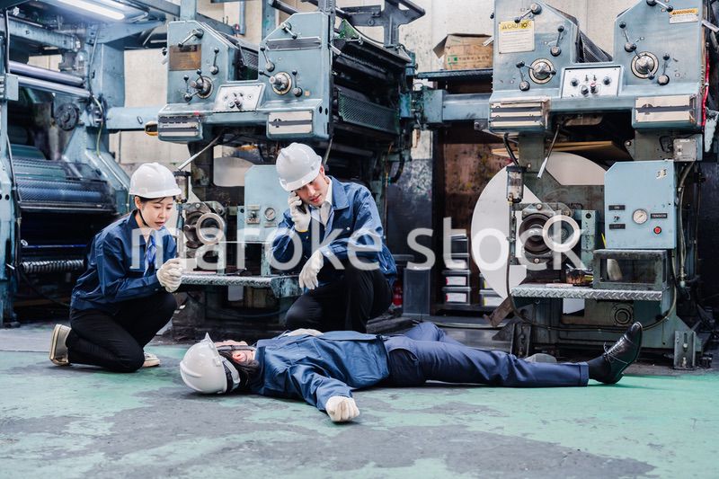 工場で救急通報をする従業員