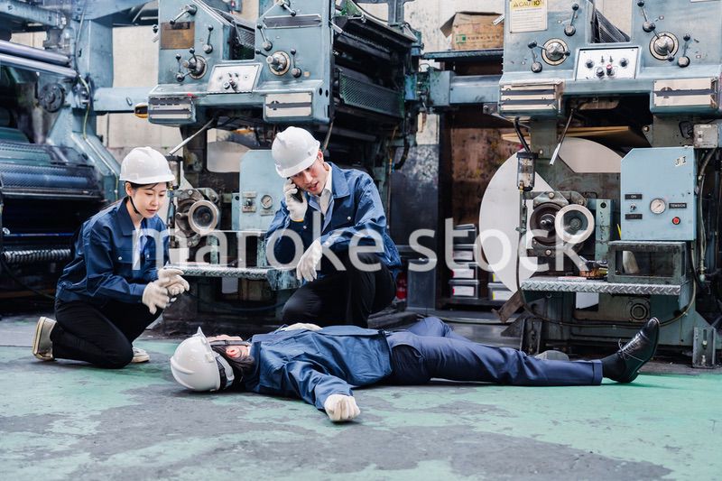 工場で救急通報をする従業員