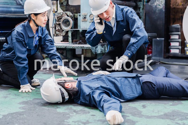 工場で救急通報をする従業員