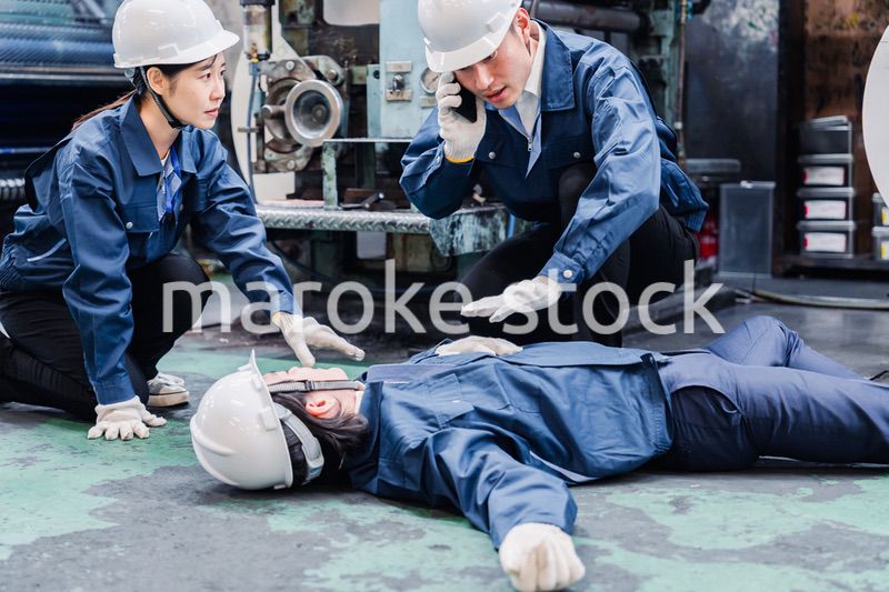 工場で救急通報をする従業員