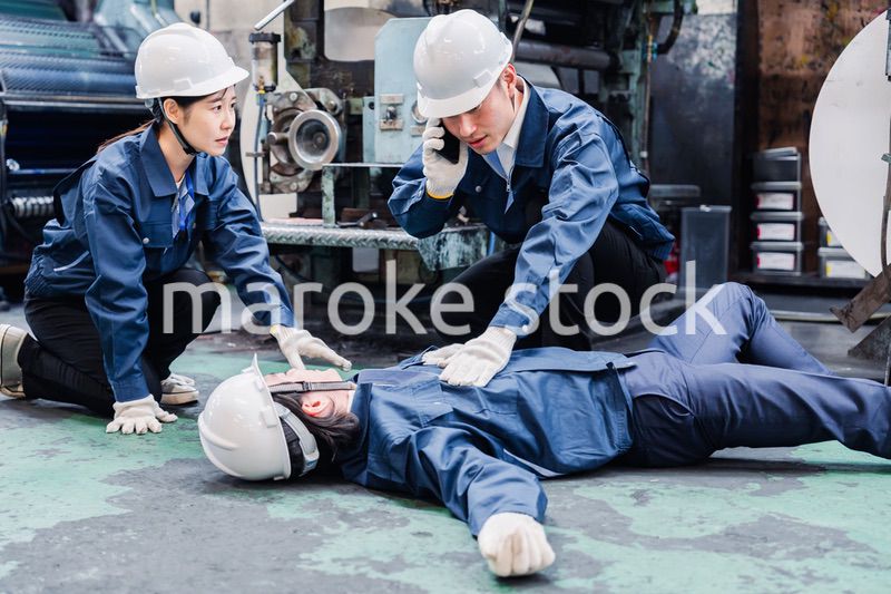 工場で救急通報をする従業員