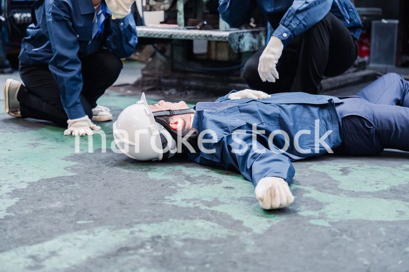 工場で救急通報をする従業員