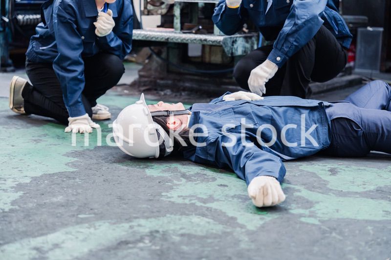 工場で救急通報をする従業員