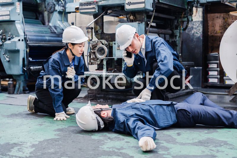 工場で救急通報をする従業員