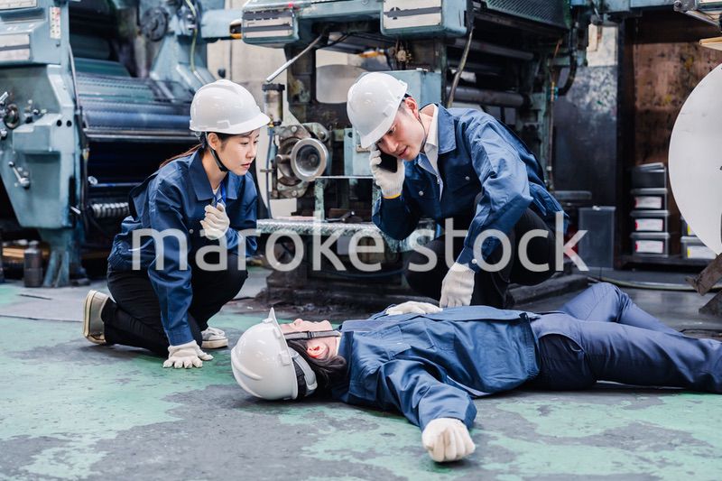 工場で救急通報をする従業員