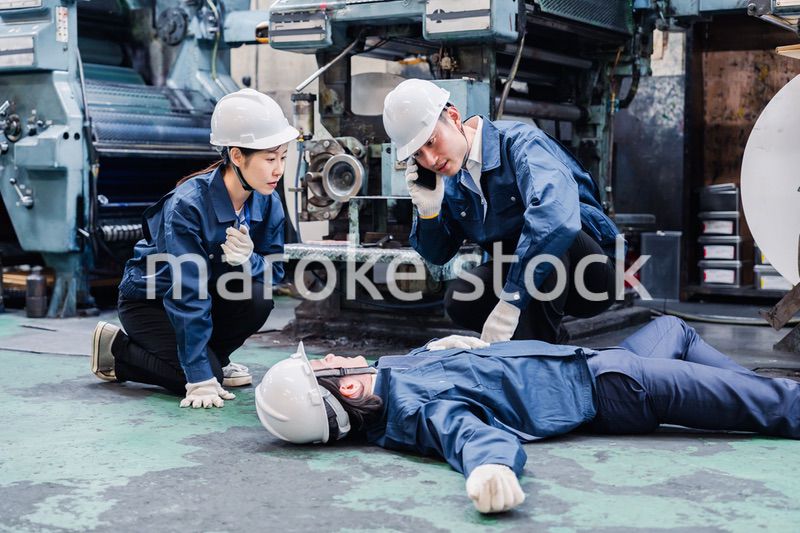 工場で救急通報をする従業員