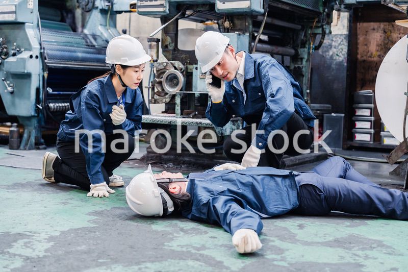 工場で救急通報をする従業員