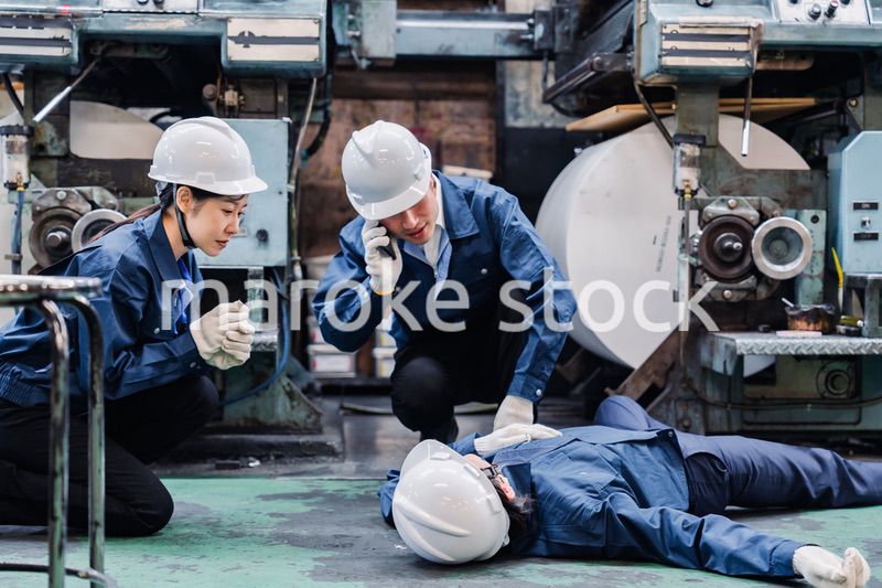 工場で救急通報をする従業員