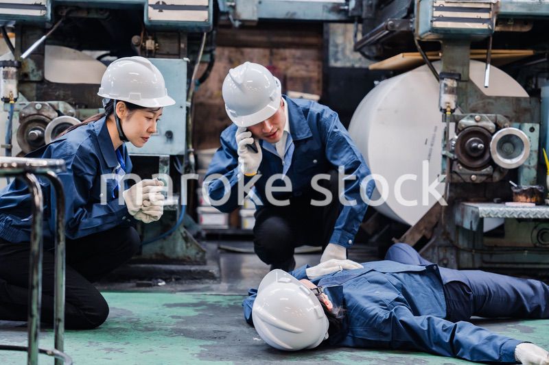 工場で救急通報をする従業員