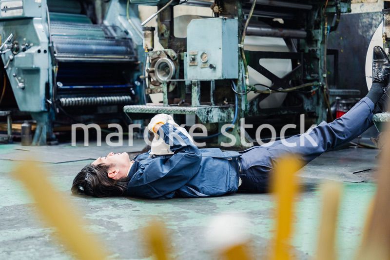 工場で寝転がる労働者