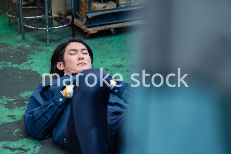 工場で寝転がる労働者