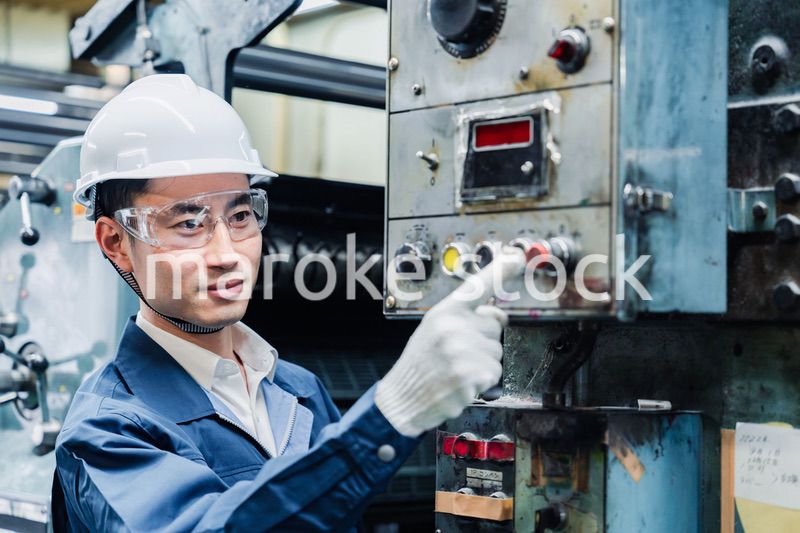 機械のスイッチを入れる男性作業員
