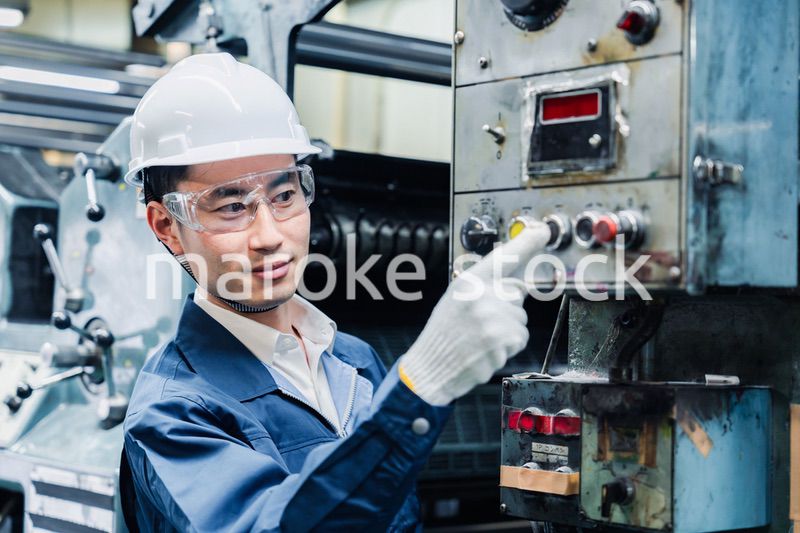 機械のスイッチを入れる男性作業員