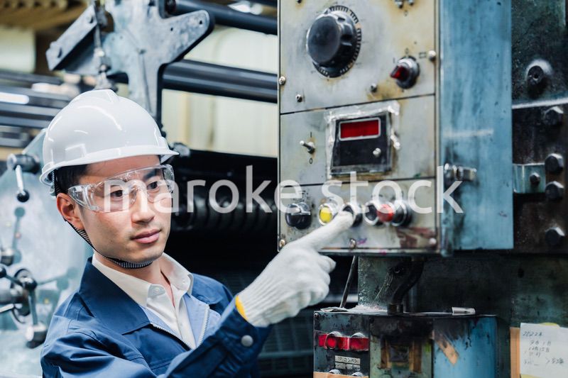 機械のスイッチを入れる男性作業員