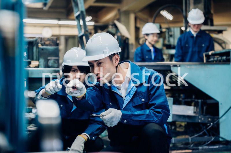 工場で機械の整備をする労働者