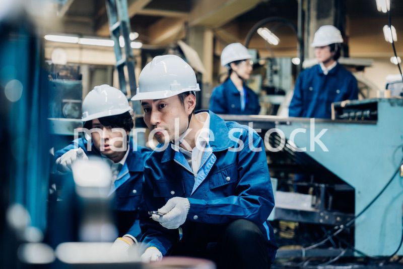 工場で機械の整備をする労働者