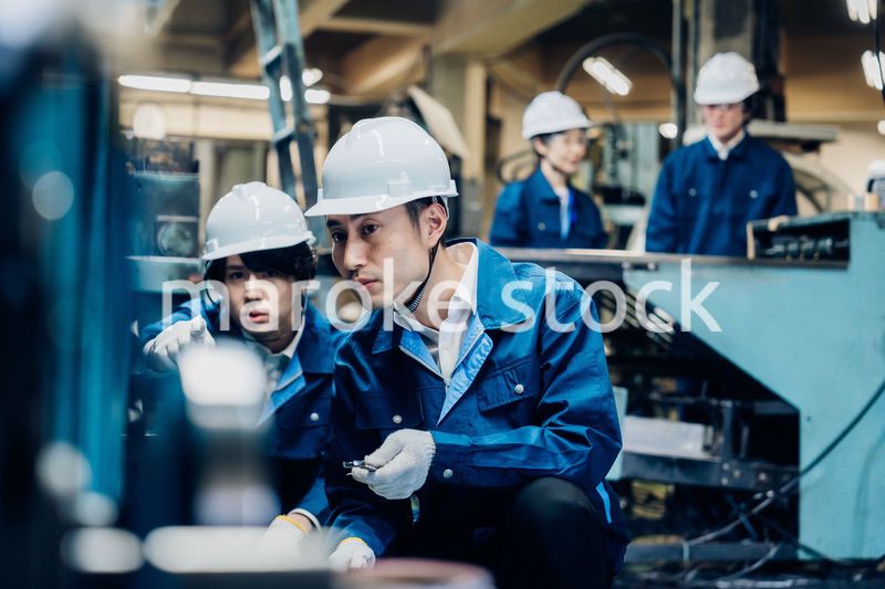 工場で機械の整備をする労働者