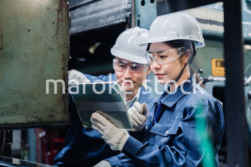 タブレット端末を確認しながら働く技術スタッフ