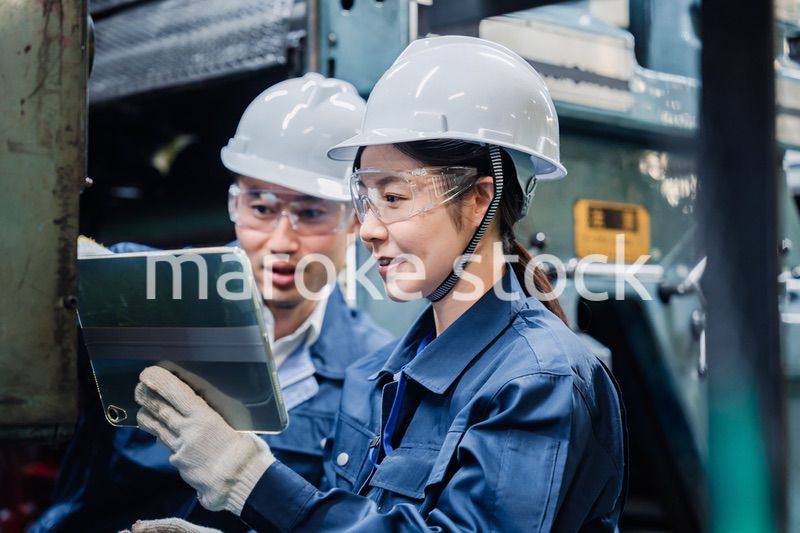 タブレット端末を確認しながら働く技術スタッフ