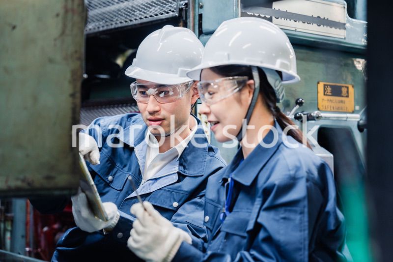 タブレット端末を確認しながら働く技術スタッフ