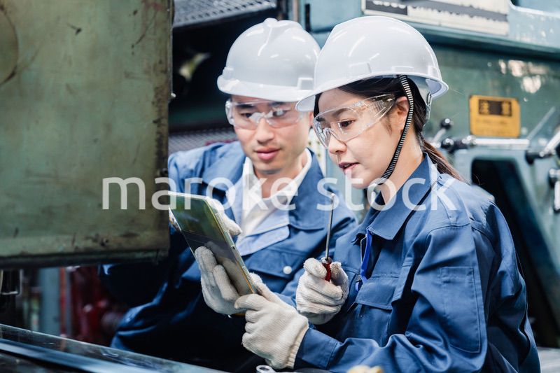 タブレット端末を確認しながら働く技術スタッフ