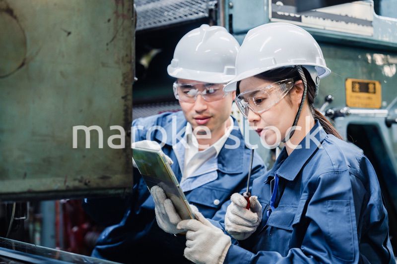 タブレット端末を確認しながら働く技術スタッフ