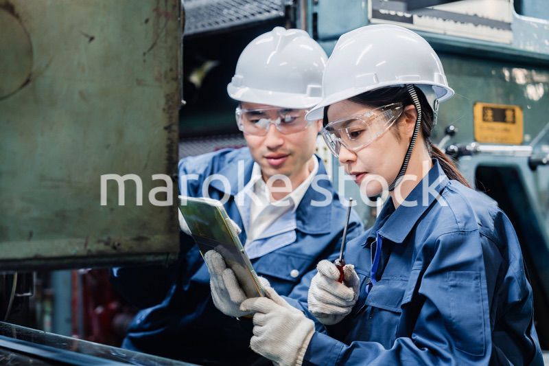 タブレット端末を確認しながら働く技術スタッフ