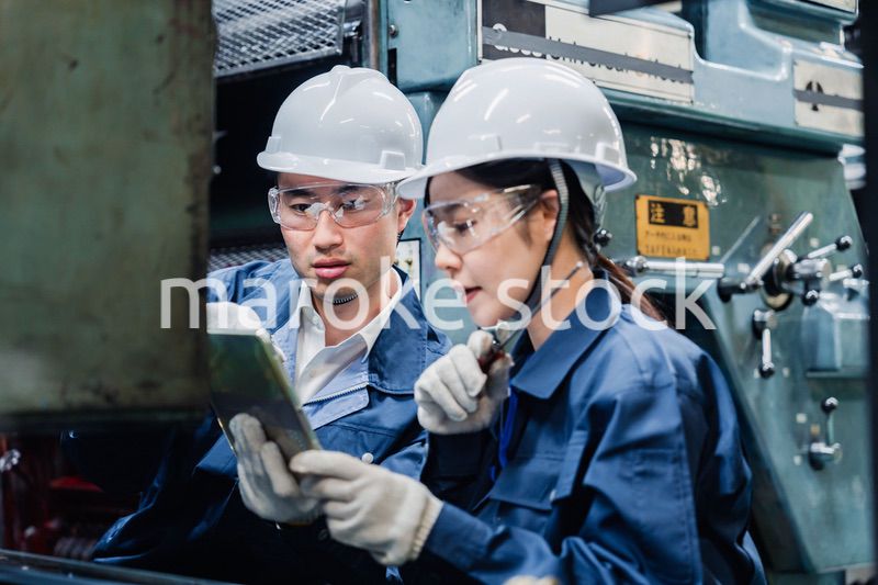 タブレット端末を確認しながら働く技術スタッフ