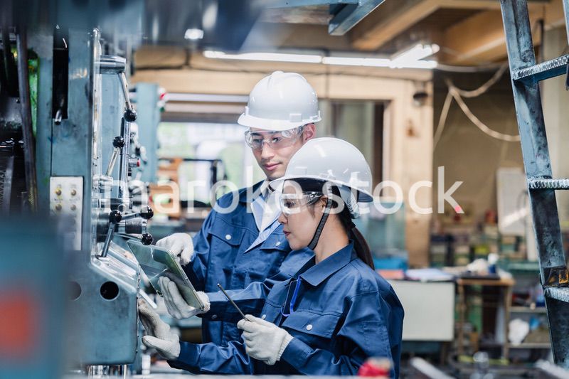 タブレット端末を確認しながら働く技術スタッフ