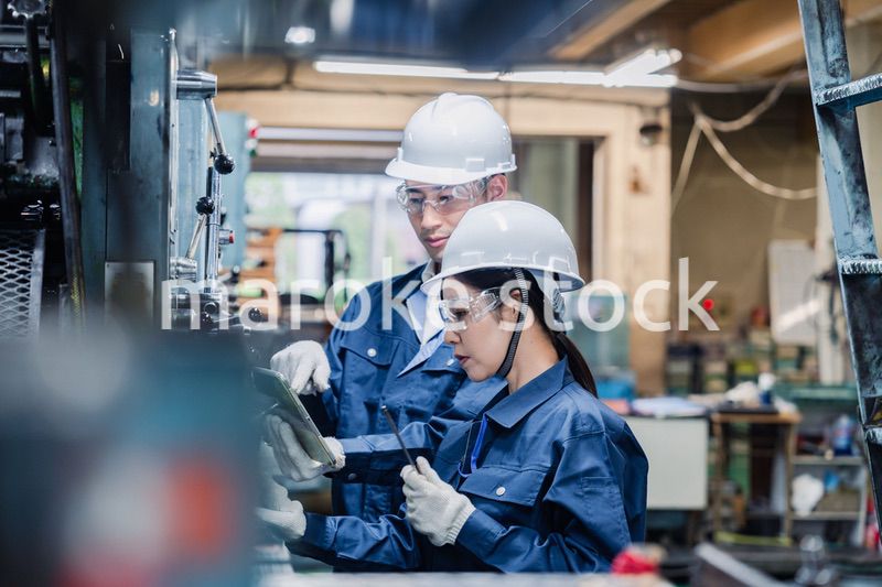 タブレット端末を確認しながら働く技術スタッフ