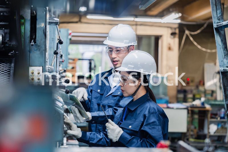 タブレット端末を確認しながら働く技術スタッフ