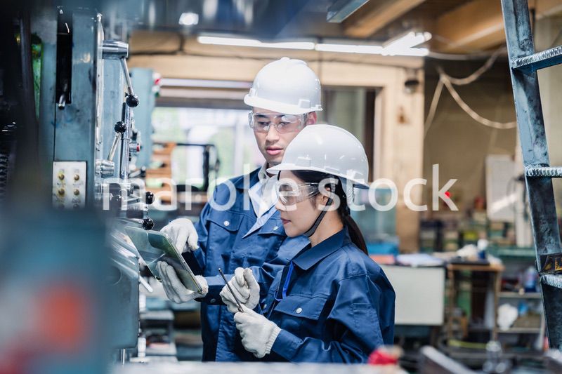 タブレット端末を確認しながら働く技術スタッフ