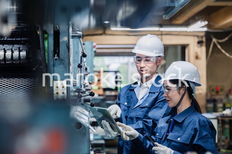 タブレット端末を確認しながら働く技術スタッフ