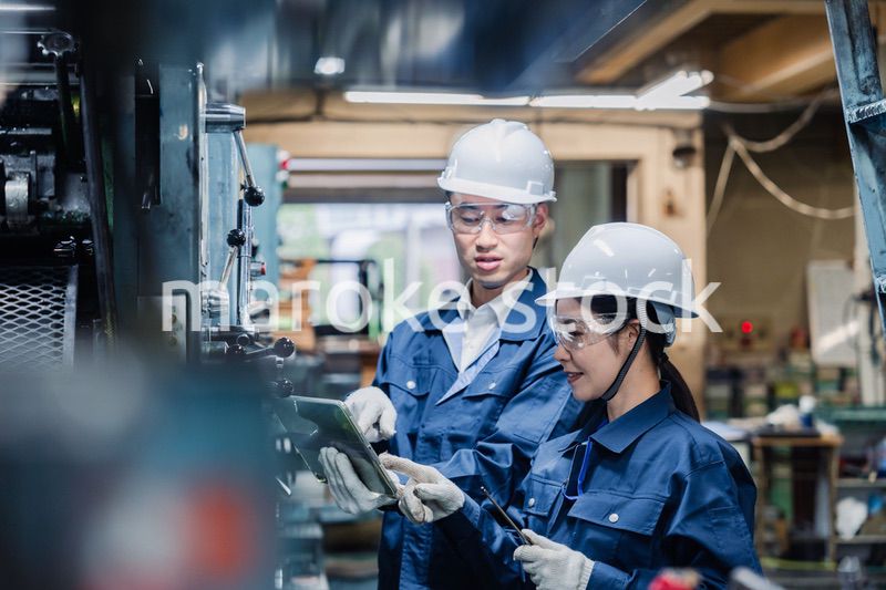 タブレット端末を確認しながら働く技術スタッフ