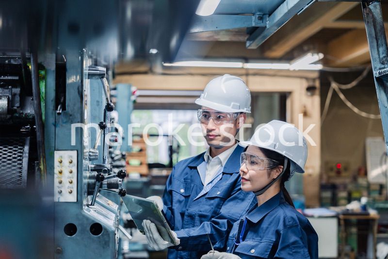 タブレット端末を確認しながら働く技術スタッフ