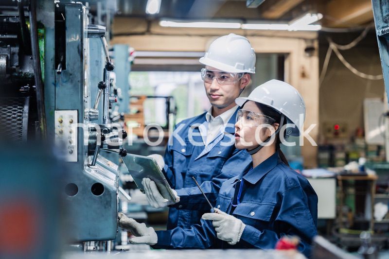 タブレット端末を確認しながら働く技術スタッフ