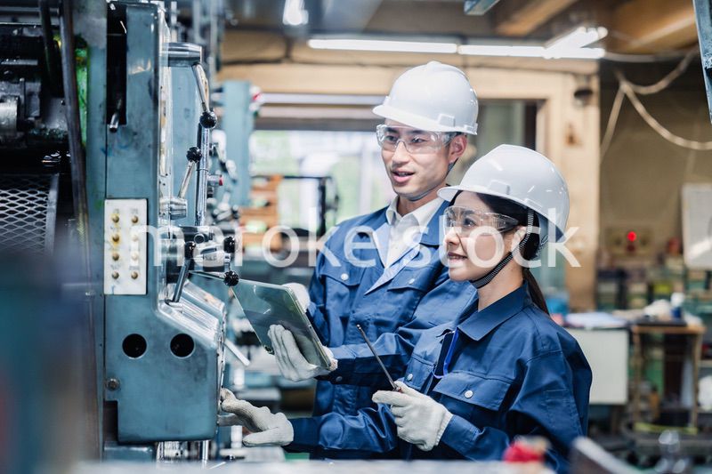 タブレット端末を確認しながら働く技術スタッフ