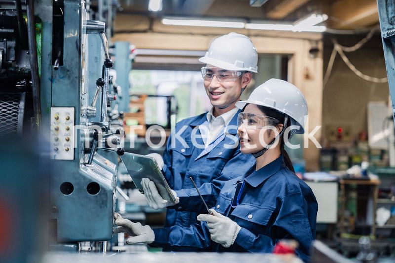 タブレット端末を確認しながら働く技術スタッフ