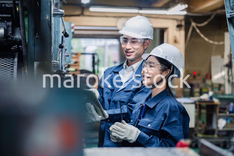 タブレット端末を確認しながら働く技術スタッフ