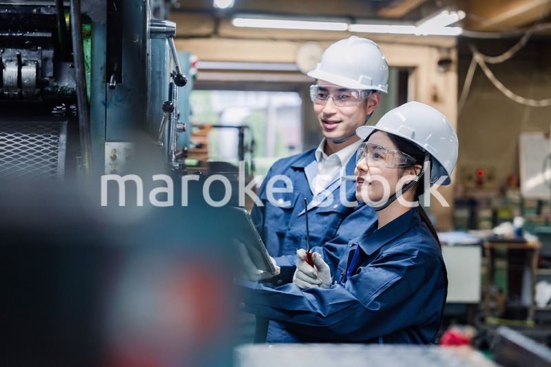 タブレット端末を確認しながら働く技術スタッフ