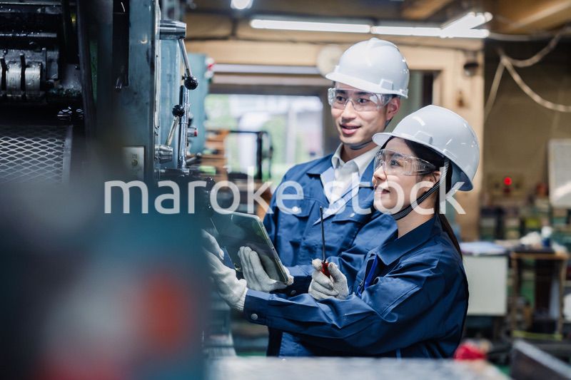 タブレット端末を確認しながら働く技術スタッフ