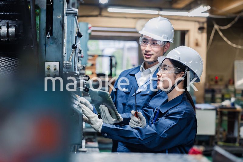 タブレット端末を確認しながら働く技術スタッフ