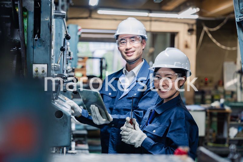 タブレット端末を確認しながら働く技術スタッフ